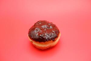 donut cake with chocolate topping on top. donut cake isolated on red background. photo
