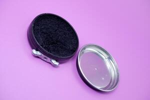 black shoe polish isolated purple background. shoe polish that is usually used with a brush to polish shoes photo
