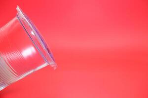 mineral water in plastic cup. mineral water isolated on red background. photo