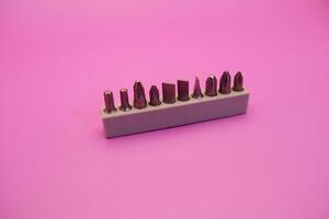 a set of screwdriver bits isolated on purple background photo