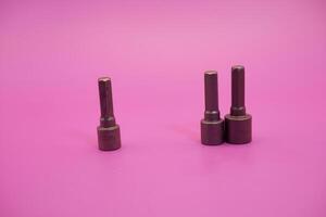 Hexagon screwdriver bit sockets measuring 7 mm, 8 mm, and 10 mm isolated on purple background. photo