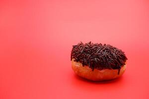 donut with chocolate sprinkle isolated on red background photo