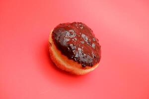 donut cake with chocolate topping on top. donut cake isolated on red background. photo
