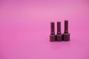 Hexagon screwdriver bit sockets measuring 7 mm, 8 mm, and 10 mm isolated on purple background. photo