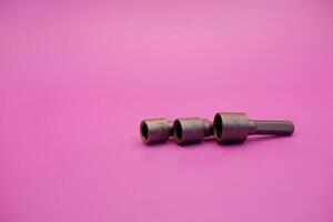 Hexagon screwdriver bit sockets measuring 7 mm, 8 mm, and 10 mm isolated on purple background. photo