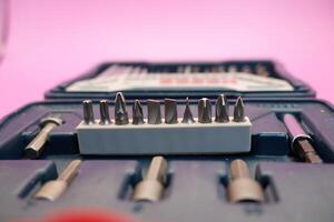 a set of screwdriver bits and sockets in a box isolated on a purple background. photo
