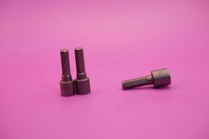 Hexagon screwdriver bit sockets measuring 7 mm, 8 mm, and 10 mm isolated on purple background. photo