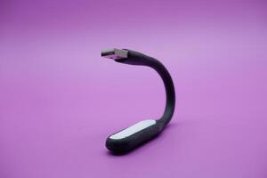 black usb lamp isolated purple background. versatile USB lamp that can be turned on by connecting to a USB port. photo