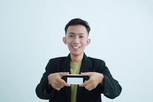 Joyful asian young businessman wear suit with tshirt and holding blank white credit card over white background photo