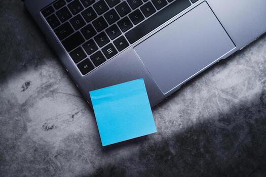 Blue post note paper on laptop. Memo paper mockup on computer. Scheduled for job or short note for work concept. Desktop view. photo