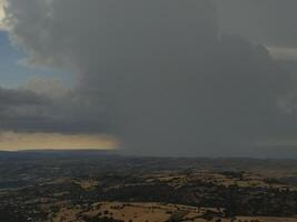 Storm front on the rolling hills, a clash between the forces of nature. Dark skies loom over the sunlit landscape. photo