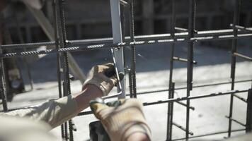 Connecting reinforcement with wire at a construction site video