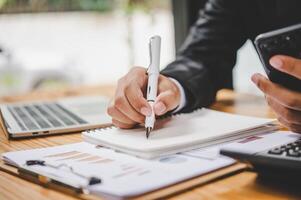 businessman pointing with pen on business report chart are working on accounts in business analysis with graphs and documentation. photo