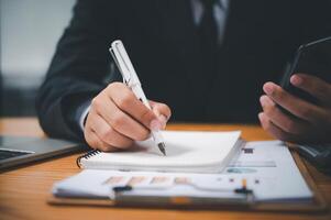 businessman pointing with pen on business report chart are working on accounts in business analysis with graphs and documentation. photo