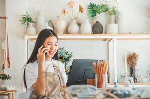 Small business owner talking on the phone with customers in a small shop. and check orders, check the orders that customers order from online retailers - online shopping photo