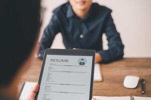 HR managers are interviewing job applicants who fill out their resume on the job application form in order to consider accepting a job as a company photo