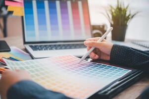 Graphic designer architects who work with laptops and color comparison tables for design work. photo