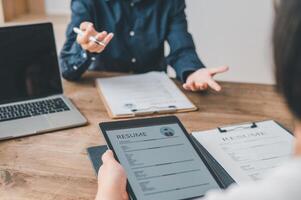 HR managers are interviewing job applicants who fill out their resume on the job application form in order to consider accepting a job as a company photo