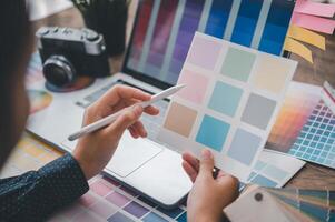 Graphic designer architects who work with laptops and color comparison tables for design work. photo