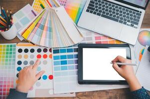 Graphic designer architects who work with laptops and color comparison tables for design work. photo