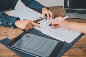 HR managers are interviewing job applicants who fill out their resume on the job application form in order to consider accepting a job as a company photo