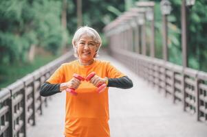 white-haired elderly person exercising in the park early in the morning. photo
