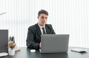 businessman sitting at worktable at modern office analyzing company performance, finance and investment photo