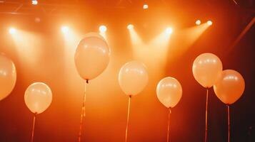 White balloons illuminated by orange stage performance photo