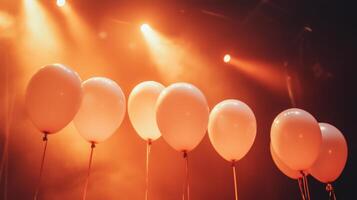 balloons illuminated by orange stage celebration lights photo