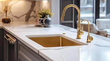 sink with gold faucet and marble countertop photo