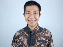smiling face expression of indonesian men wearing batik clothes looking camera photo