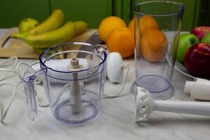 Disassembled blender and fruits on the table for making tasty drink with vitamins. Strengthening health with fruits and sports cocktails. Making smoothies in blender photo