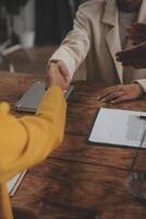 Lawyer shaking hands with a client making about documents, contracts, agreements, cooperation agreements with a female client at the lawyer's desk and a hammer at the table. photo