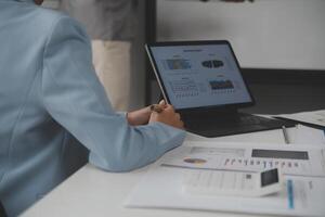 Close up of Business team analyzing income charts and graphs with modern laptop computer. Business analysis and strategy concept. photo