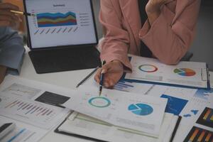 Close up of Business team analyzing income charts and graphs with modern laptop computer. Business analysis and strategy concept. photo