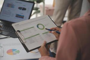 Close up of Business team analyzing income charts and graphs with modern laptop computer. Business analysis and strategy concept. photo