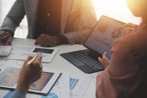 Close up of Business team analyzing income charts and graphs with modern laptop computer. Business analysis and strategy concept. photo