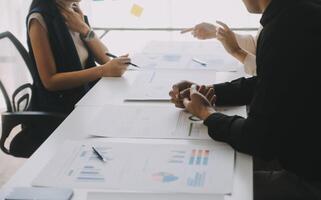 Financial analysts analyze business financial reports on a digital tablet planning investment project during a discussion at a meeting of corporate showing the results of their successful teamwork. photo