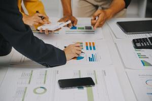 Financial analysts analyze business financial reports on a digital tablet planning investment project during a discussion at a meeting of corporate showing the results of their successful teamwork. photo