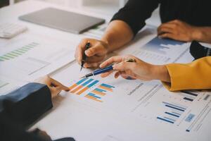 Financial analysts analyze business financial reports on a digital tablet planning investment project during a discussion at a meeting of corporate showing the results of their successful teamwork. photo