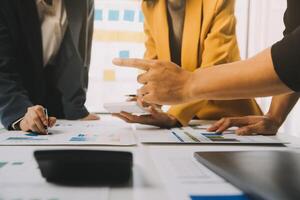Financial analysts analyze business financial reports on a digital tablet planning investment project during a discussion at a meeting of corporate showing the results of their successful teamwork. photo