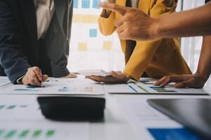 Financial analysts analyze business financial reports on a digital tablet planning investment project during a discussion at a meeting of corporate showing the results of their successful teamwork. photo