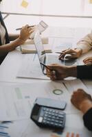 Financial analysts analyze business financial reports on a digital tablet planning investment project during a discussion at a meeting of corporate showing the results of their successful teamwork. photo