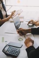 Financial analysts analyze business financial reports on a digital tablet planning investment project during a discussion at a meeting of corporate showing the results of their successful teamwork. photo