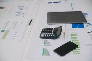 Financial analysts analyze business financial reports on a digital tablet planning investment project during a discussion at a meeting of corporate showing the results of their successful teamwork. photo