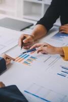 Financial analysts analyze business financial reports on a digital tablet planning investment project during a discussion at a meeting of corporate showing the results of their successful teamwork. photo
