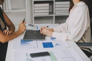 Financial analysts analyze business financial reports on a digital tablet planning investment project during a discussion at a meeting of corporate showing the results of their successful teamwork. photo