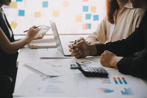 Financial analysts analyze business financial reports on a digital tablet planning investment project during a discussion at a meeting of corporate showing the results of their successful teamwork. photo