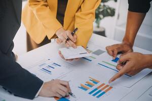 Financial analysts analyze business financial reports on a digital tablet planning investment project during a discussion at a meeting of corporate showing the results of their successful teamwork. photo