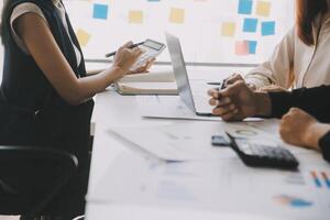Financial analysts analyze business financial reports on a digital tablet planning investment project during a discussion at a meeting of corporate showing the results of their successful teamwork. photo